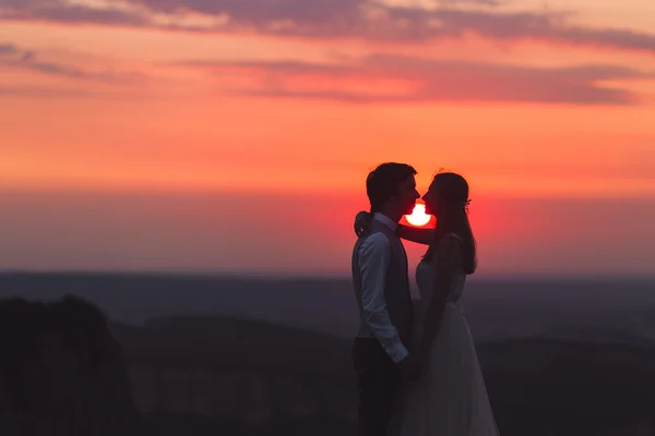 Jeunes mariés au beau coucher du soleil — Photo