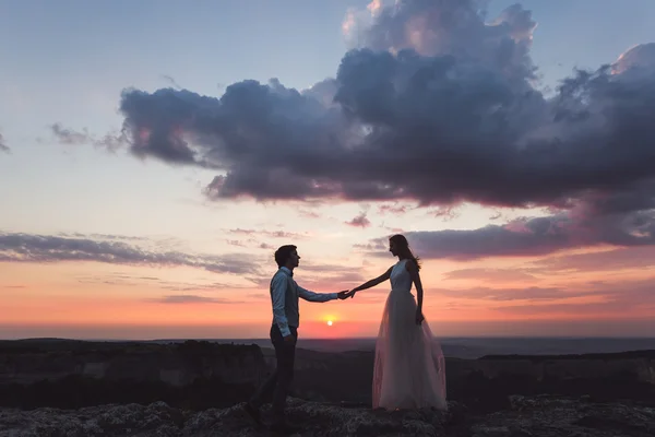 Jeunes mariés au beau coucher du soleil — Photo