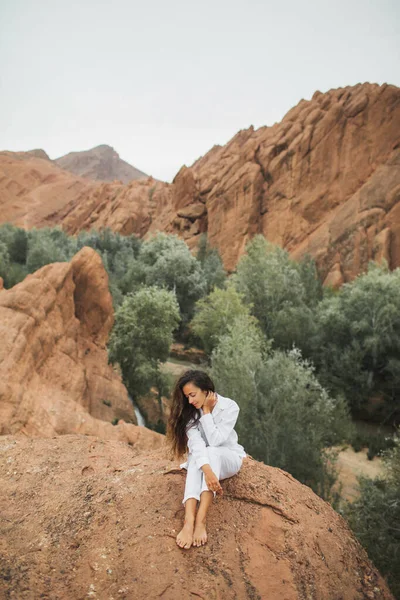 白い座ってモロッコのトドラ峡谷の景色を楽しむ美しいブルネットの女性 自然との調和と自由の概念 旅行生活 — ストック写真