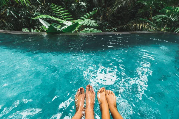 在户外绿松石清澈的水边 绿树成荫的豪华游泳池里 两只脚踏在一起 热带蜜月 休闲度假 — 图库照片