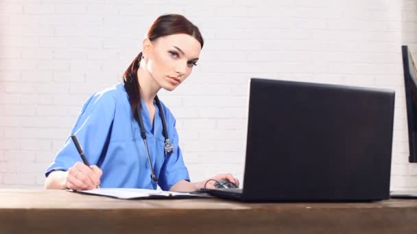 Läkaren bakom en dator — Stockvideo