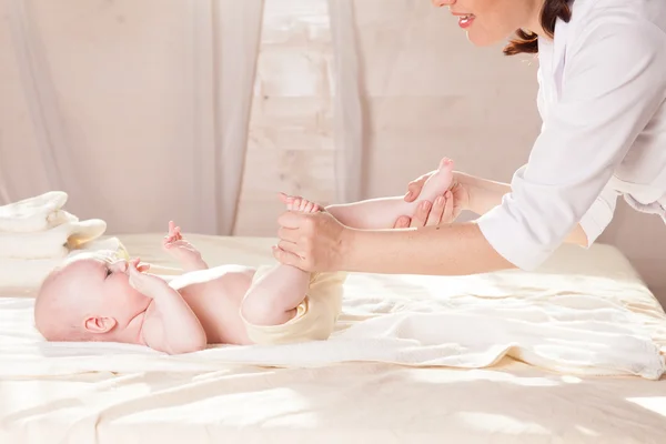 Legen gir babymassasje – stockfoto