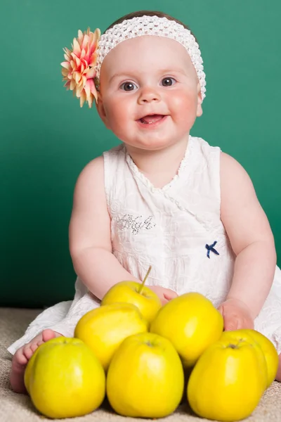 Маленькая девочка с желтыми яблоками — стоковое фото