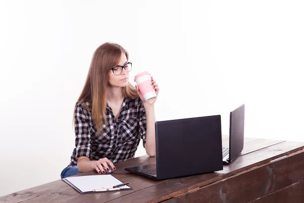 コーヒーを飲みながらノート パソコンに座ってオフィスで女の子 — ストック写真