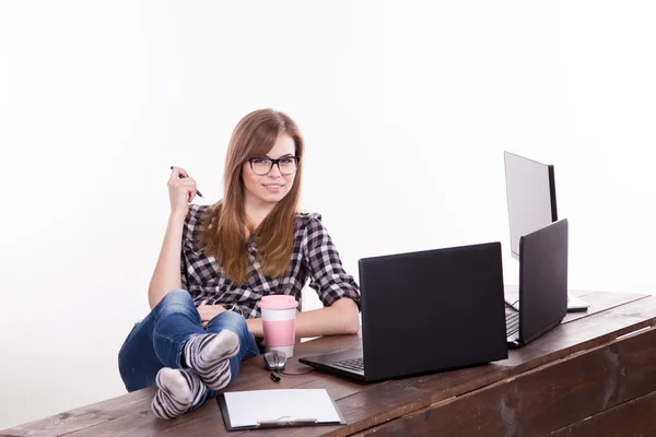 The girl in an Office sitting at a laptop with coffee Stock Photo