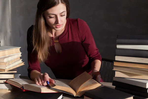 Menina senta-se livros e ler um livro — Fotografia de Stock