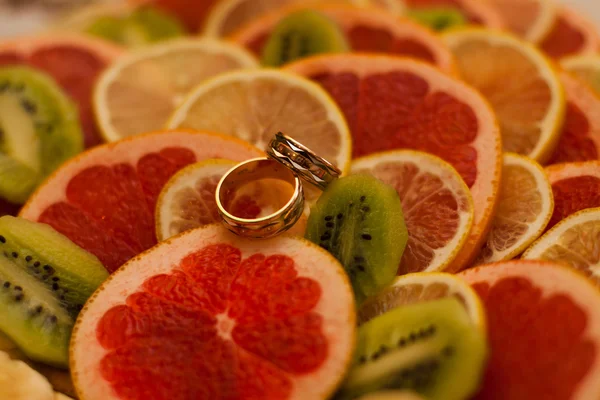 Two wedding rings on oranges — Stock Photo, Image