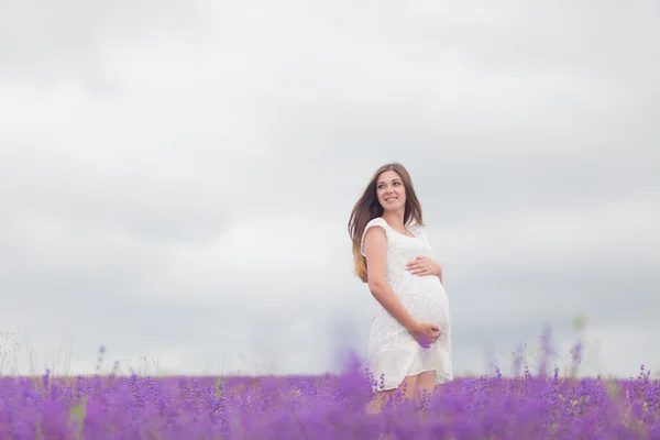 Lavendel fält och en glad gravid kvinna — Stockfoto