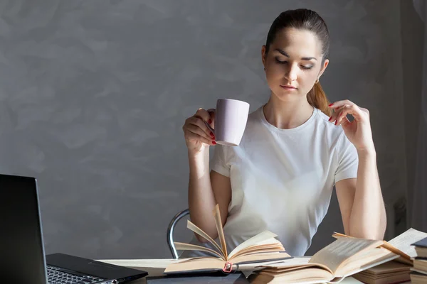 Girl is preparing for the exam and reads a book Stock Picture