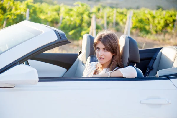 The girl sitting behind the wheel of a white convertible — Stock Photo, Image