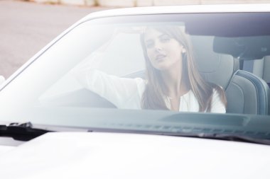üstü açık beyaz bir arabayla oturan kız