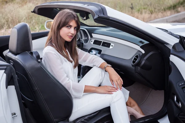 Chica sentada en un cabriolet blanco con puerta abierta — Foto de Stock