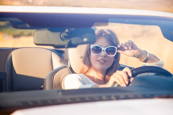 La chica sentada al volante de un convertible blanco — Foto de Stock