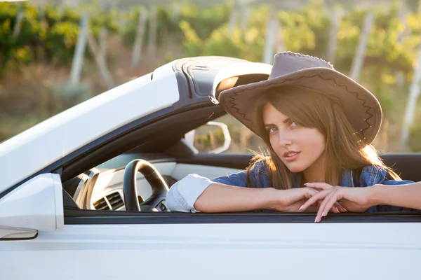 Cowboy girl sits in a cabriolet — Stock Photo, Image