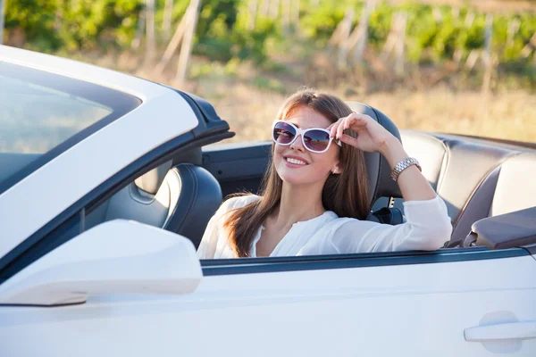 La chica sentada al volante de un convertible blanco — Foto de Stock
