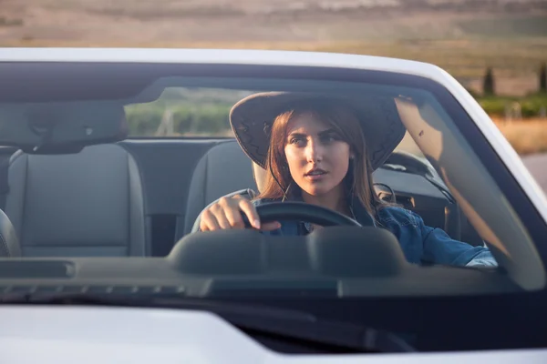 Conductor de niña vaquera en convertible blanco — Foto de Stock