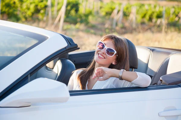 Motorista menina senta-se em cabriolet branco — Fotografia de Stock