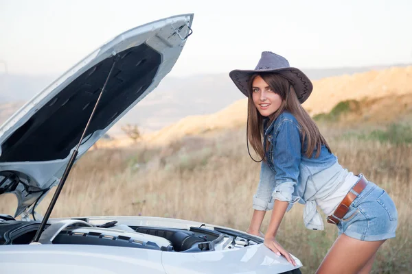 girl looks at a car engine