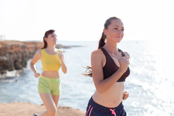 Girls on the run at the sea play sports — Stock Photo, Image