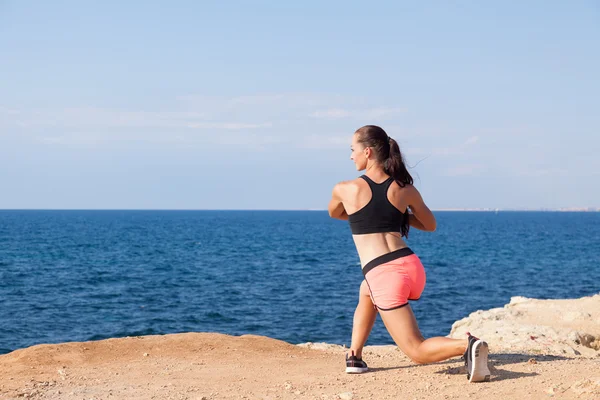 Girl engaged in fitness on the beach by the sea — Stock Photo, Image