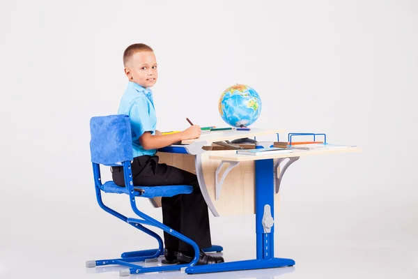 少年は彼の机で宿題をやって座ってください。 — ストック写真