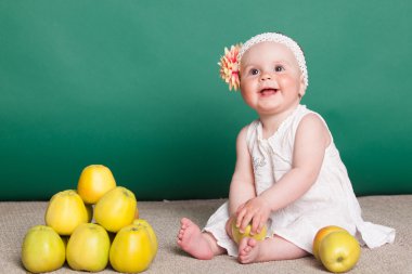 küçük kız sarı elma ile oturuyor