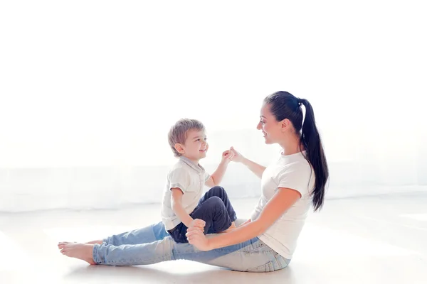 Mutter und Sohn sitzen auf dem Boden und kuscheln sich — Stockfoto