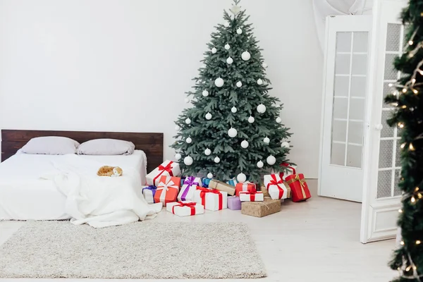 Christmas tree pine with gifts by the bed in the bedroom new year decor white background 2021 2022