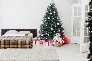 Noel ağacı çamı, yatak odasındaki yatağın yanında hediyelerle yeni yıl dekorasyonu beyaz arka plan 2021 2022