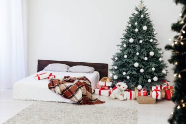 Noel ağacı çamı, yatak odasındaki yatağın yanında hediyelerle yeni yıl dekorasyonu beyaz arka plan 2021 2022