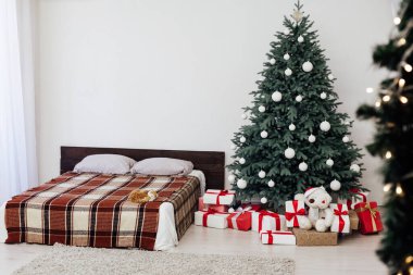Noel ağacı çamı, yatak odasındaki yatağın yanında hediyelerle yeni yıl dekorasyonu beyaz arka plan 2021 2022