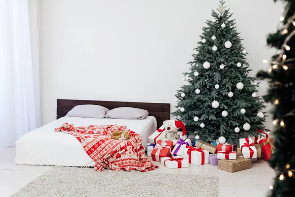 Neujahrskarte Schlafzimmer Interieur mit rotem Bett Dekor und Weihnachtsbaum mit Geschenken — Stockfoto