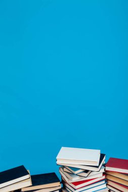 Kütüphanedeki sınavlar için mavi arkaplan üzerine bir yığın eğitim kitabı