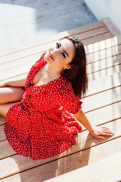 Linda mulher morena na moda em um vestido de verão vermelho caminha na rua — Fotografia de Stock