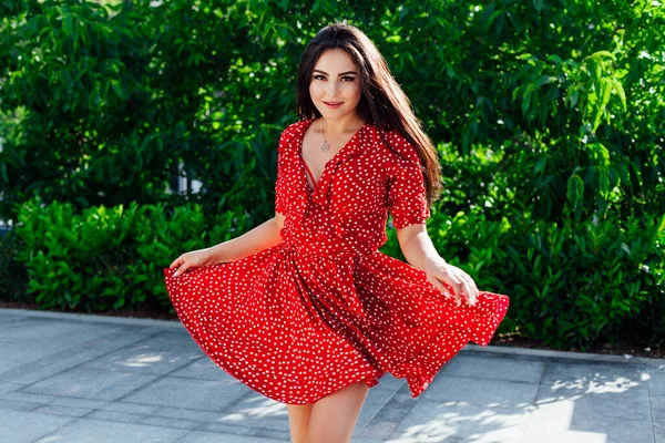 Hermosa mujer morena de moda en un vestido rojo de verano camina en la calle — Foto de Stock