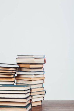 Kütüphanede beyaz bir arkaplan üzerine okumak ve eğitim için kitap yığınları