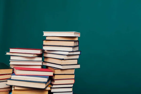 Pile di libri per la lettura e l'istruzione su uno sfondo verde nella biblioteca universitaria — Foto Stock