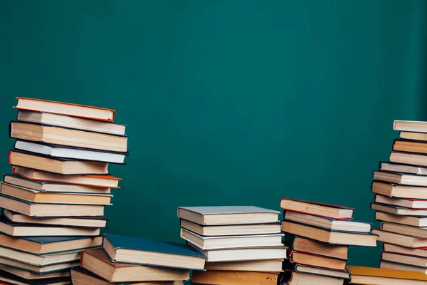 Stapels boeken voor lezen en onderwijs op een groene achtergrond in de universiteitsbibliotheek — Stockfoto