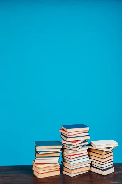 Pilas de libros para la lectura y la educación en un fondo azul en la biblioteca de la universidad — Foto de Stock