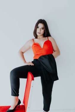 Güzel, modaya uygun, iş elbisesi giymiş esmer bir kadın.