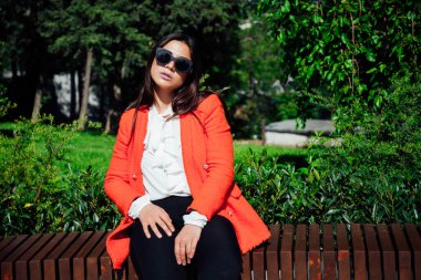 Güzel, modaya uygun, iş elbisesi giymiş esmer bir kadın.