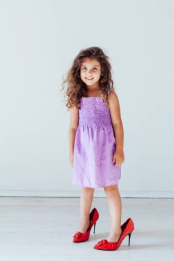 Elbise ve anne ayakkabısı giymiş güzel, modaya uygun bir kız.