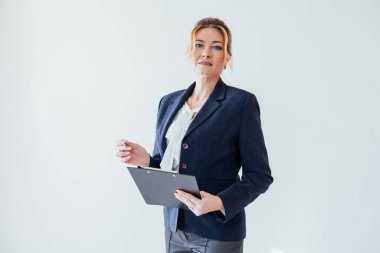 İş elbiseli kadın kayıt için klasör tabletiyle ofiste.