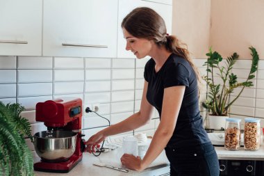 Güzel kadın pasta şefi tatlı krema yapıyor.