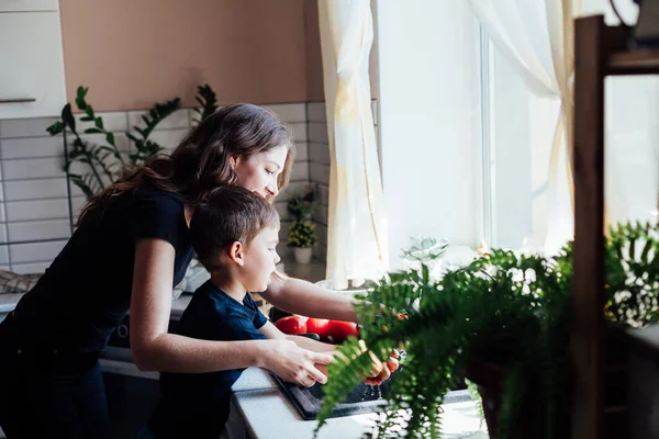 Bela mãe e filho lavar legumes frescos — Fotografia de Stock