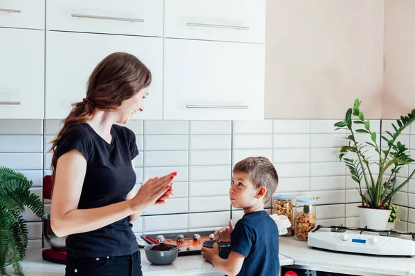 Mutter Konditorin und Sohn kochen süße Kuchen in der Küche — Stockfoto