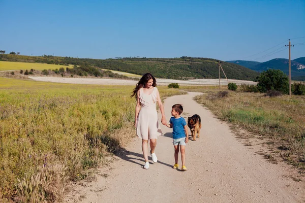 Mère avec fils et chien promenade sur la route rurale — Photo