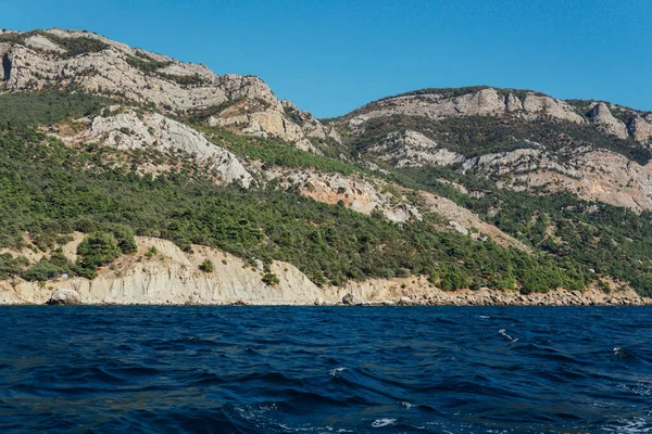 Mavi deniz dağları yeşil orman ve gökyüzü manzarası — Stok fotoğraf