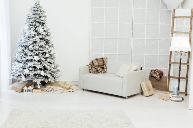 Beyaz karlı Noel ağacı hediyeler ile evin içini süsleyen yeni yıl kartpostalı.