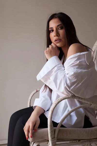 Retrato de una hermosa morena oriental de moda en una camisa blanca — Foto de Stock